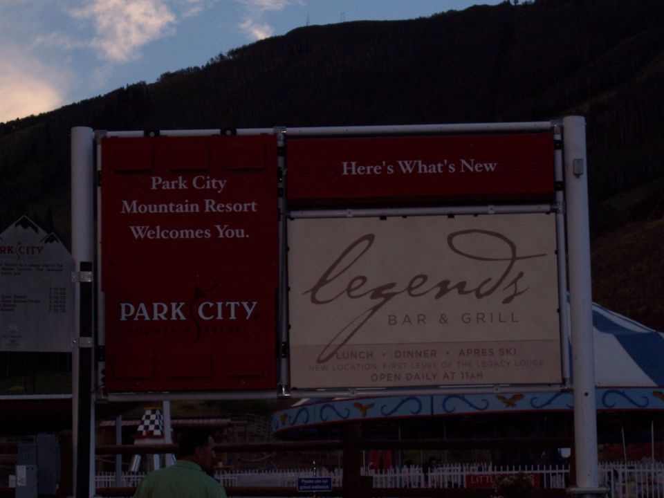 Park City Mountain Resort welcome sign and Legends Bar & Grill ad at dusk