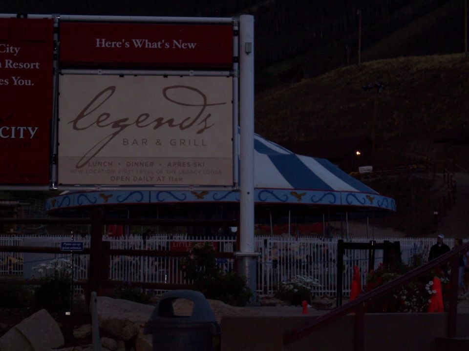 Legends Bar & Grill sign and carousel tent at a resort at dusk