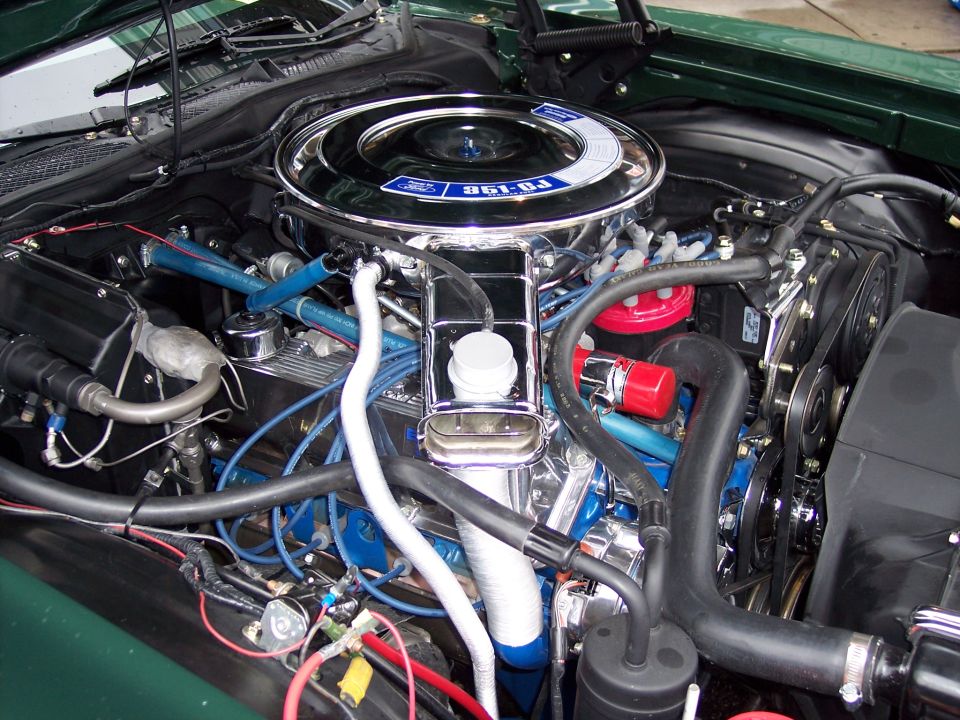 Ford engine bay with chrome air cleaner, blue plug wires and green fenders