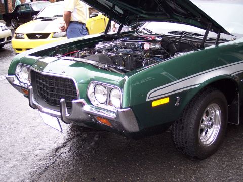 1972 Ford Ranchero - The front quarter view of a green 1972 Ford Ranchero shows its engine with the hood up.