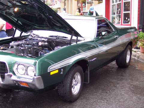 1972 Ford Ranchero - A green pickup truck from the 1970s is displayed with its hood open, revealing the engine compartment.