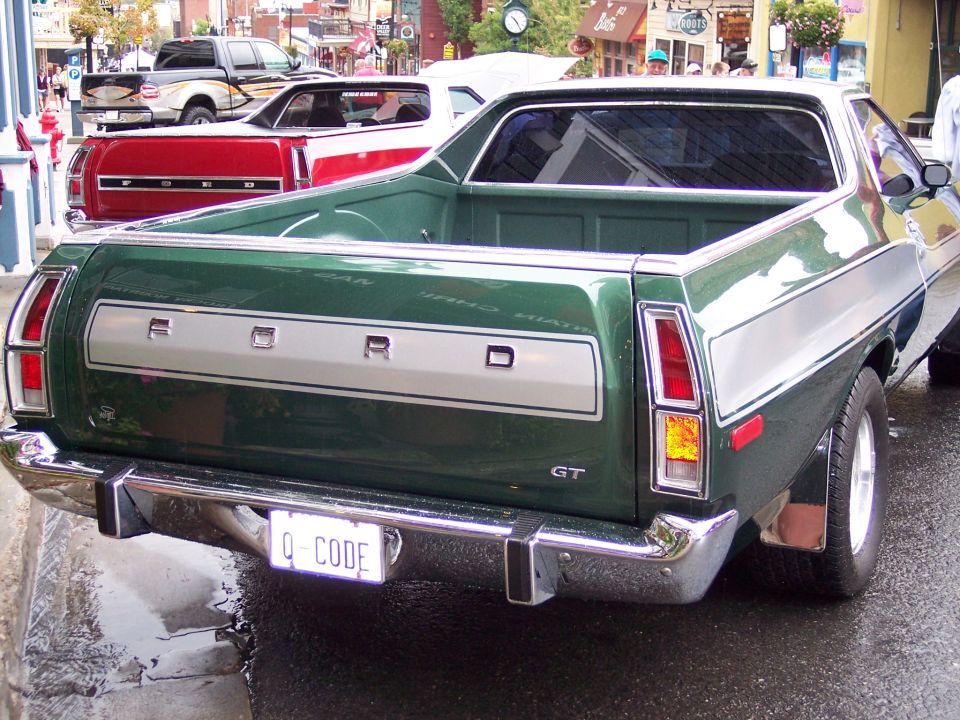 Green Ford Ranchero rear view with FORD tailgate and Q-CODE plate on wet street