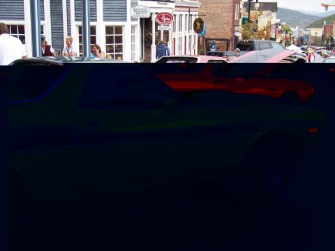 1972 Ford Ranchero - A street scene with multiple vehicles and pedestrians in front of shops.