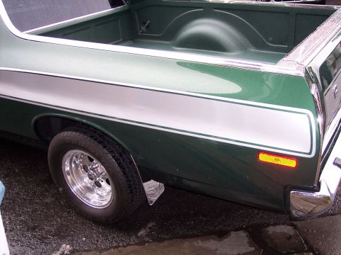 1972 Ford Ranchero - Rear view of a green 1972 Ford Ranchero, a distinctive silver stripe along the bed and a chrome bumper.