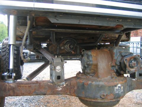 1992 Ford Mustang - Close-up view of the heavily modified undercarriage of an off-road vehicle, highlighting the differential and suspension with a skull emble…
