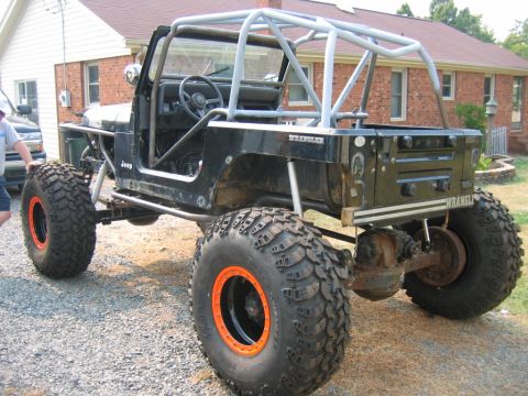 1992 Ford Mustang - Customized Jeep Wrangler oversized tires and a full roll cage, modified for off-road use.