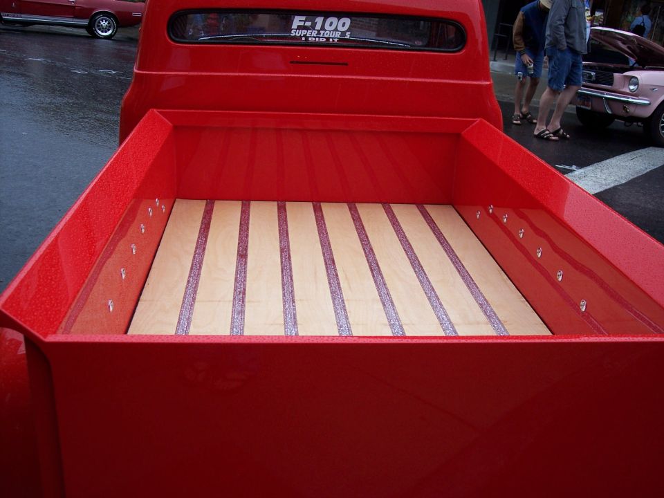 Red truck bed with wood plank floor and red inlay strips, F-100 window decal above
