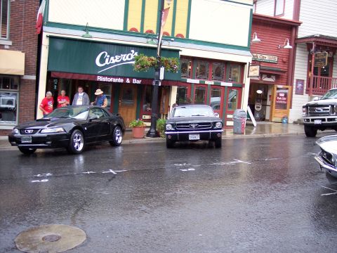 1972 Ford Ranchero - A black 1966 Ford Mustang is parked on a wet street in front of Ciseros Ristorante & Bar, with a newer black Mustang convertible also visib…