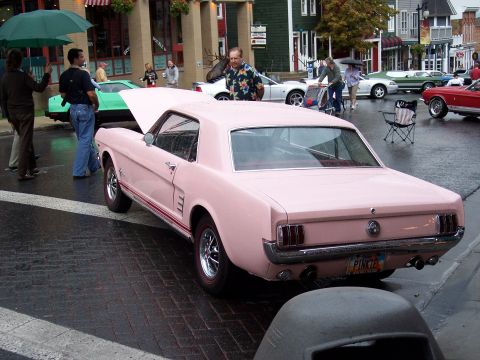 1972 Ford Ranchero - A classic pink Ford Mustang is displayed on a rainy day, with its hood open.
