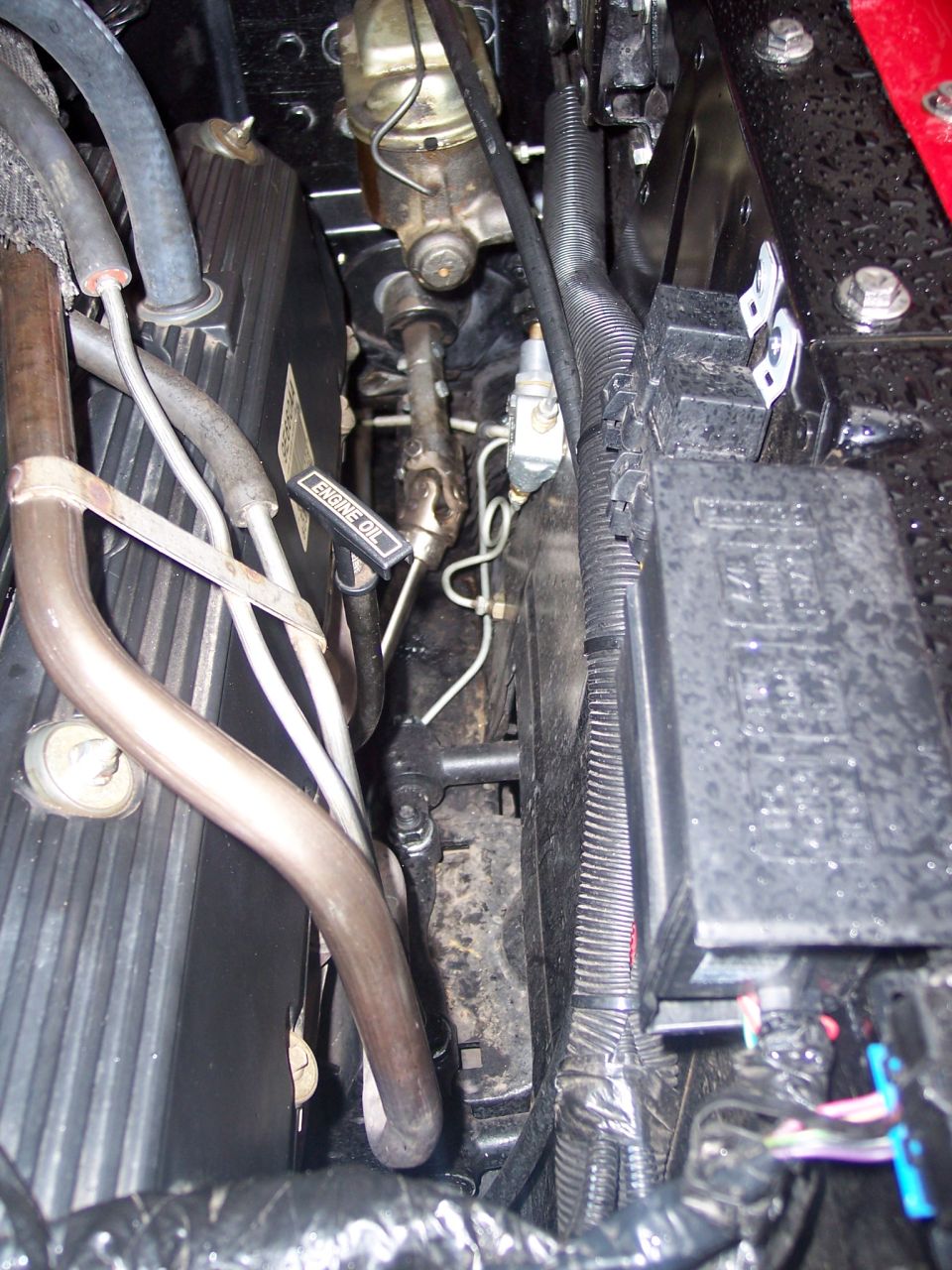 Engine bay detail with dipstick, master cylinder, wiring loom and fuse box