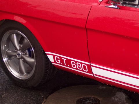 Red car side with white 'G.T. 680' stripe and five-spoke wheel