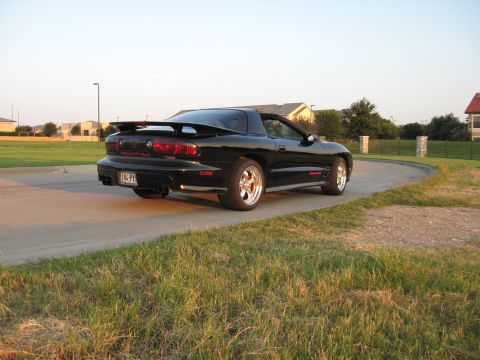 2002 Pontiac Trans Am - A black 2002 Pontiac Trans Am is parked on a paved surface with grass in the foreground.