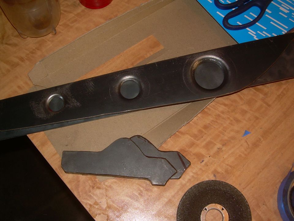 Metal part with three circular indentations and two car-shaped cutouts