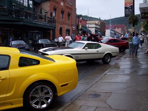 1972 Ford Ranchero - A white 1971 Ford Mustang Mach 1 is parked on a wet street in front of the Riverhorse Cafe.
