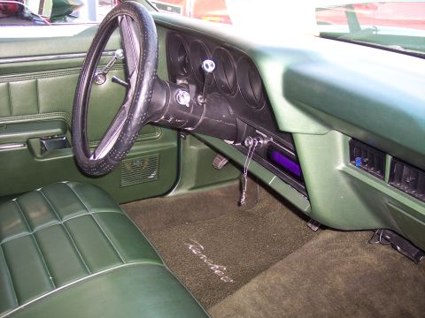 1972 Ford Ranchero - The interior of a 1972 Ford Ranchero features green upholstery and a carpet with the model name embroidered.