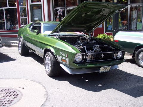 1972 Ford Ranchero - A green 1971 Ford Mustang Mach 1 is parked with its hood open, revealing the engine bay.