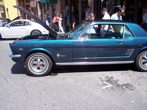 1972 Ford Ranchero - Teal 1965 Ford Mustang coupe with hood open, parked on street next to a white Mustang.