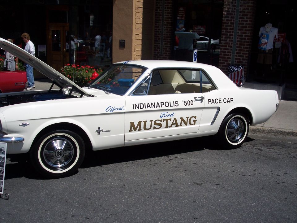 White 1960s Ford Mustang coupe with Indianapolis 500 Pace Car markings, hood open