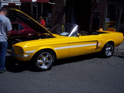 1972 Ford Ranchero - Yellow 1967 Ford Mustang convertible parked on street with hood open, another car behind.