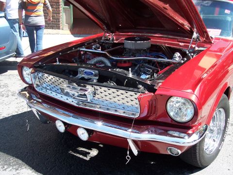 1972 Ford Ranchero - Front view of a red 1965 Ford Mustang, its chrome grille and exposed engine bay.