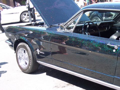 1972 Ford Ranchero - A dark blue coupe with a glitter finish, hood open, is seen from the side. The vehicle appears to be a 1965 Ford Mustang.