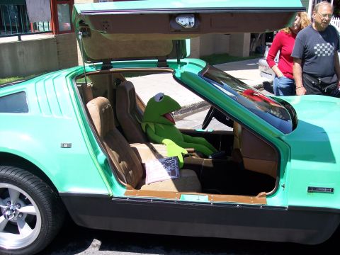 1972 Ford Ranchero - Kermit the Frog takes the wheel of a unique teal car, its gull-wing doors raised for entry.