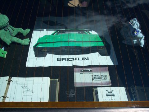 1972 Ford Ranchero - Poster and owner's manual for a Bricklin car displayed on a vehicle's rear window.