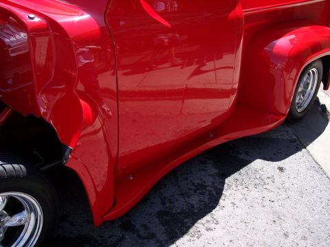1972 Ford Ranchero - Side view of a red pickup truck a custom running board and chrome wheel.