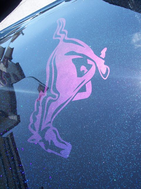 1972 Ford Ranchero - A custom graphic adorns the hood of a car with a dark, sparkling finish.