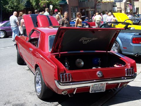 1972 Ford Ranchero - A red 1967 Ford Mustang coupe is displayed with its hood and trunk open, a prominent horse emblem in the trunk.