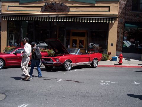 1972 Ford Ranchero - Classic red Mustang convertible on display with hood open, next to another vehicle.