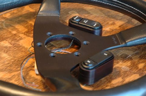 1984 Ford Bronco - Close-up of a steering wheel hub showing cruise control buttons and wiring.