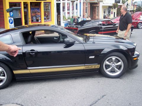 1972 Ford Ranchero - A black Ford Mustang Shelby GT-H is parked on the street, with other cars visible in the background.