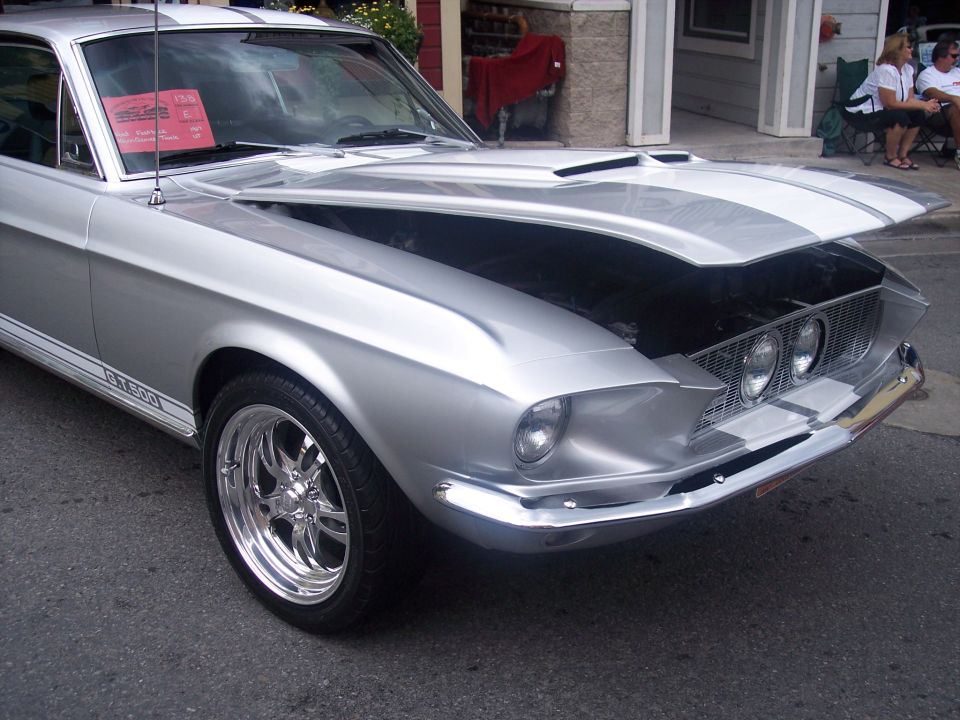 Silver 1968 Ford Mustang GT500 with racing stripes and hood open