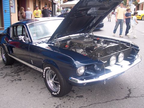 1972 Ford Ranchero - A dark blue coupe with its hood open, revealing the engine, is parked on a street.