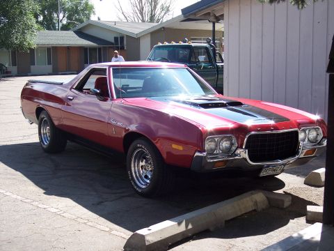 1972 Ford Ranchero - Red 1972 Ford Ranchero with black stripes, parked in a lot.