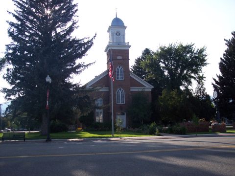 1972 Ford Ranchero - A historic brick building stands tall with a clock tower and an American flag waving proudly.