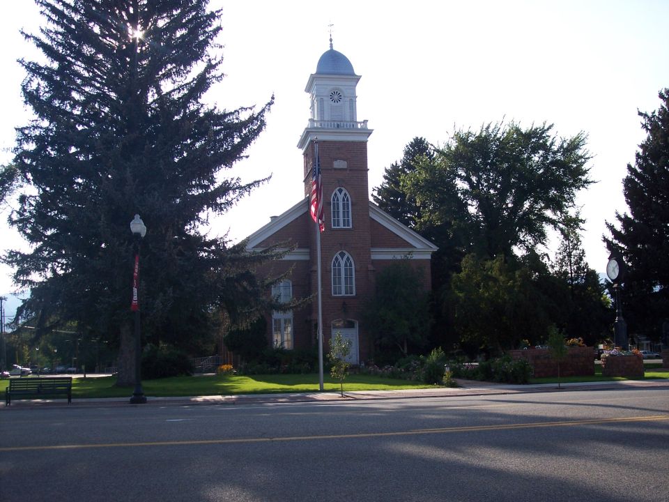 Brick building with a clock tower and an American flag in front