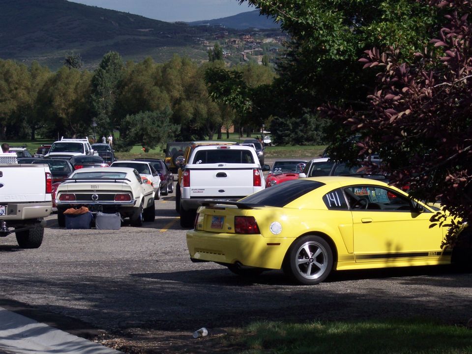 Yellow coupe with racing numbers 141 on door, parked in a lot