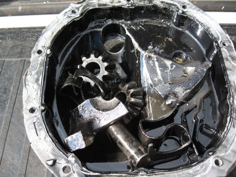 1994 Ford Bronco - Differential housing shows internal damage with broken gears submerged in oil.