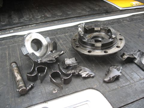1994 Ford Bronco - The aftermath of a catastrophic differential failure, with numerous fractured metal pieces strewn across a textured surface.