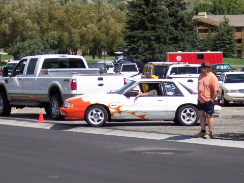 1972 Ford Ranchero - A white coupe with flame decals and a racing number is parked next to a white pickup truck.