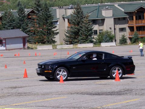 1972 Ford Ranchero - A black Ford Mustang GT navigates an autocross course marked by orange cones.