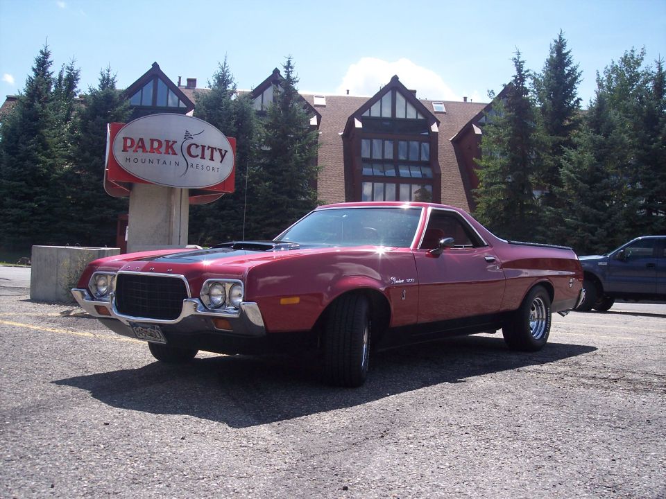 Red 1970s Ford Ranchero parked in front of Park City Mountain Resort sign