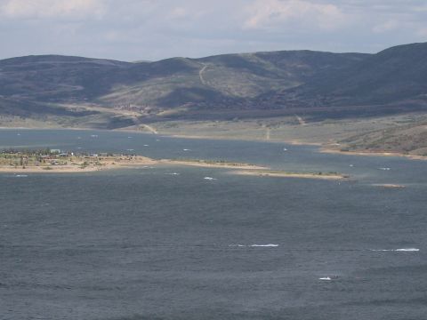 1972 Ford Ranchero - A wide view of a lake with mountains in the background and a small settlement on the far shore.