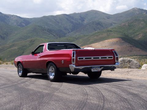 1972 Ford Ranchero - This red 1972 Ford Ranchero is parked on a road with a mountainous landscape behind it.