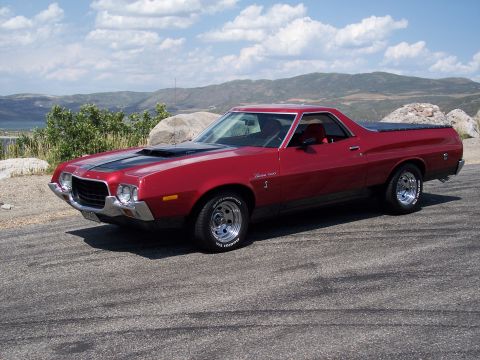 1972 Ford Ranchero - A red 1972 Ford Ranchero is parked on a scenic overlook with mountains and a lake in the background.
