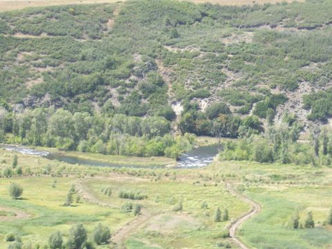 1972 Ford Ranchero - A wide view of a river valley with rolling hills and vegetation under a clear sky.