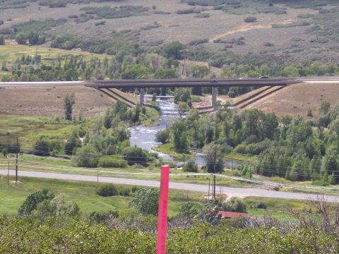 1972 Ford Ranchero - A highway overpass spans a river, with two vehicles visible on the road above.