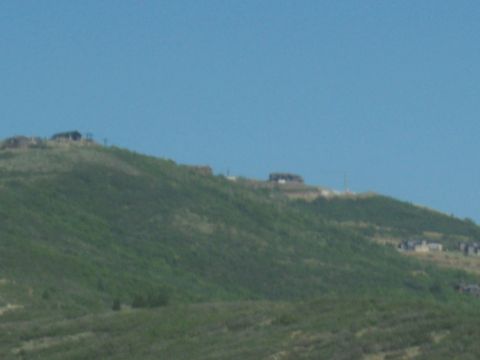 1972 Ford Ranchero - Several structures are visible on the crest of a large, green hill.